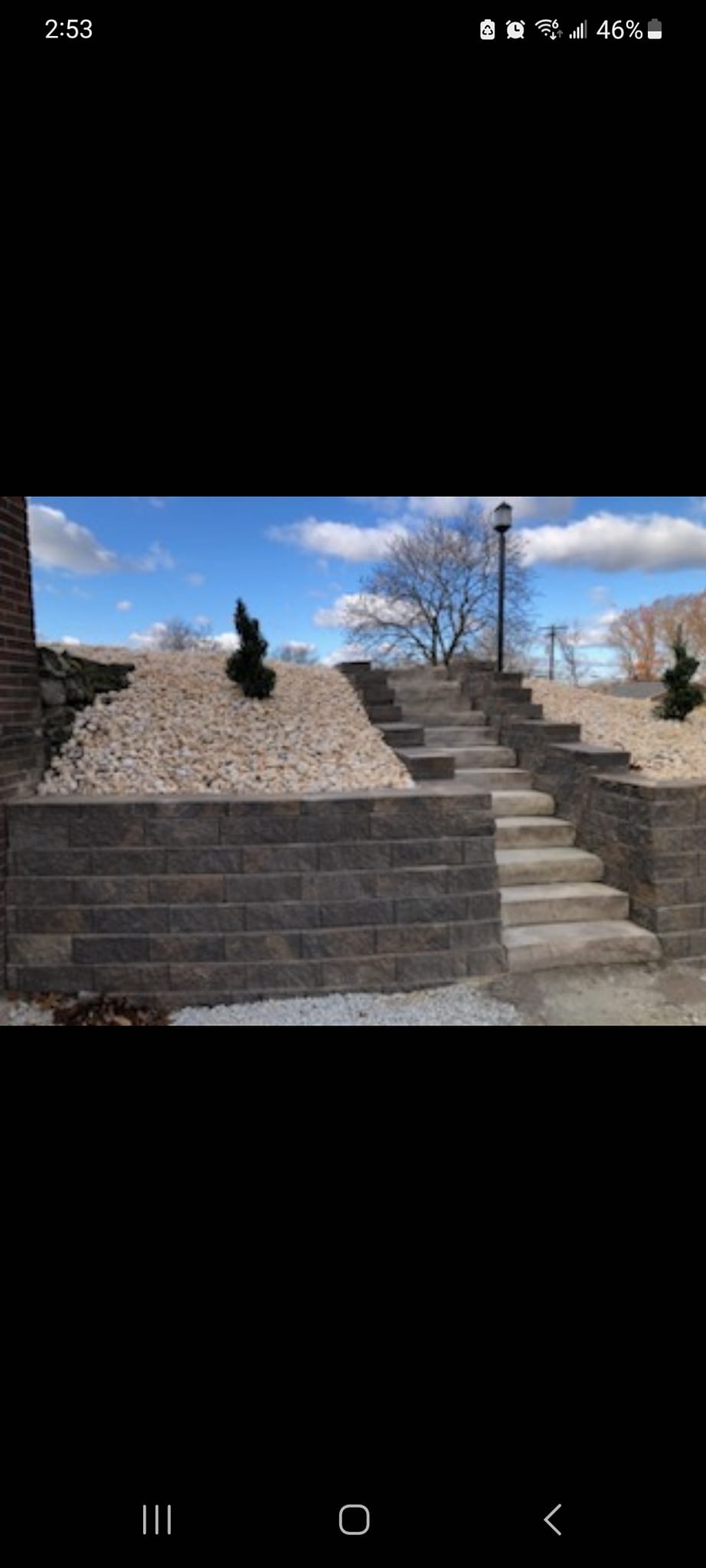 Large block retaining wall with stone steps and gravel landscaping