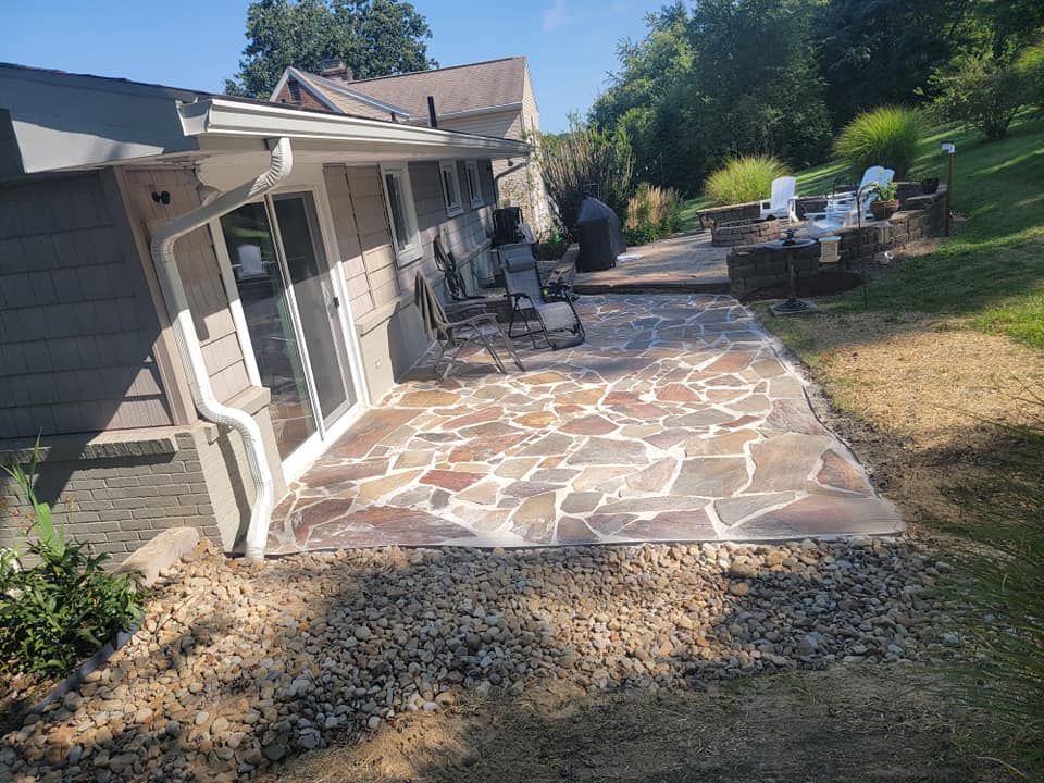 Flagstone patio with river rock border and stone fire pit area