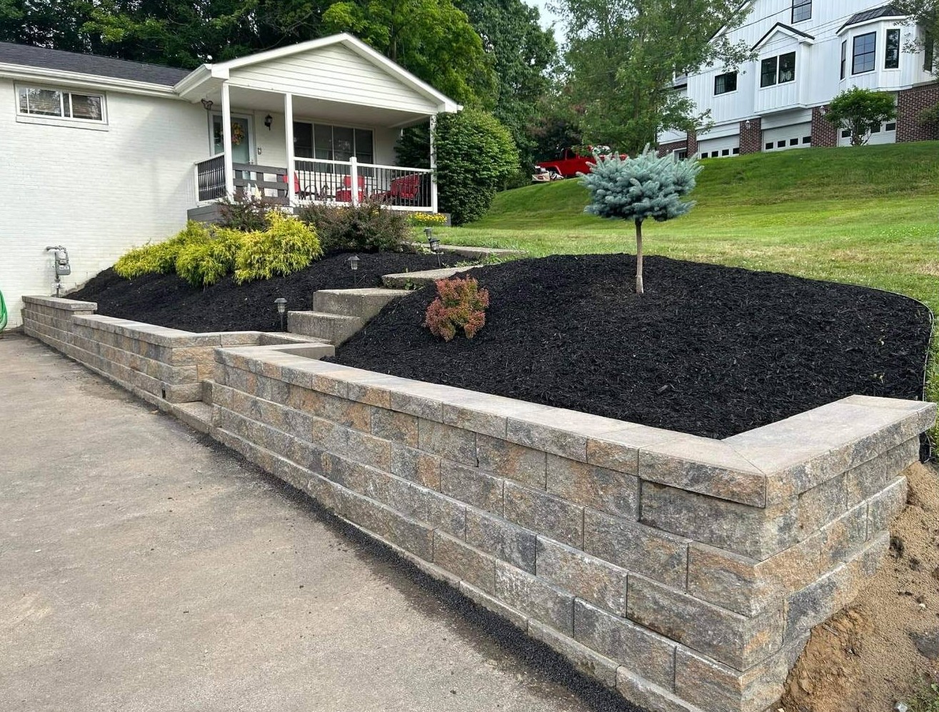 Retaining wall with fresh black mulch and new plantings