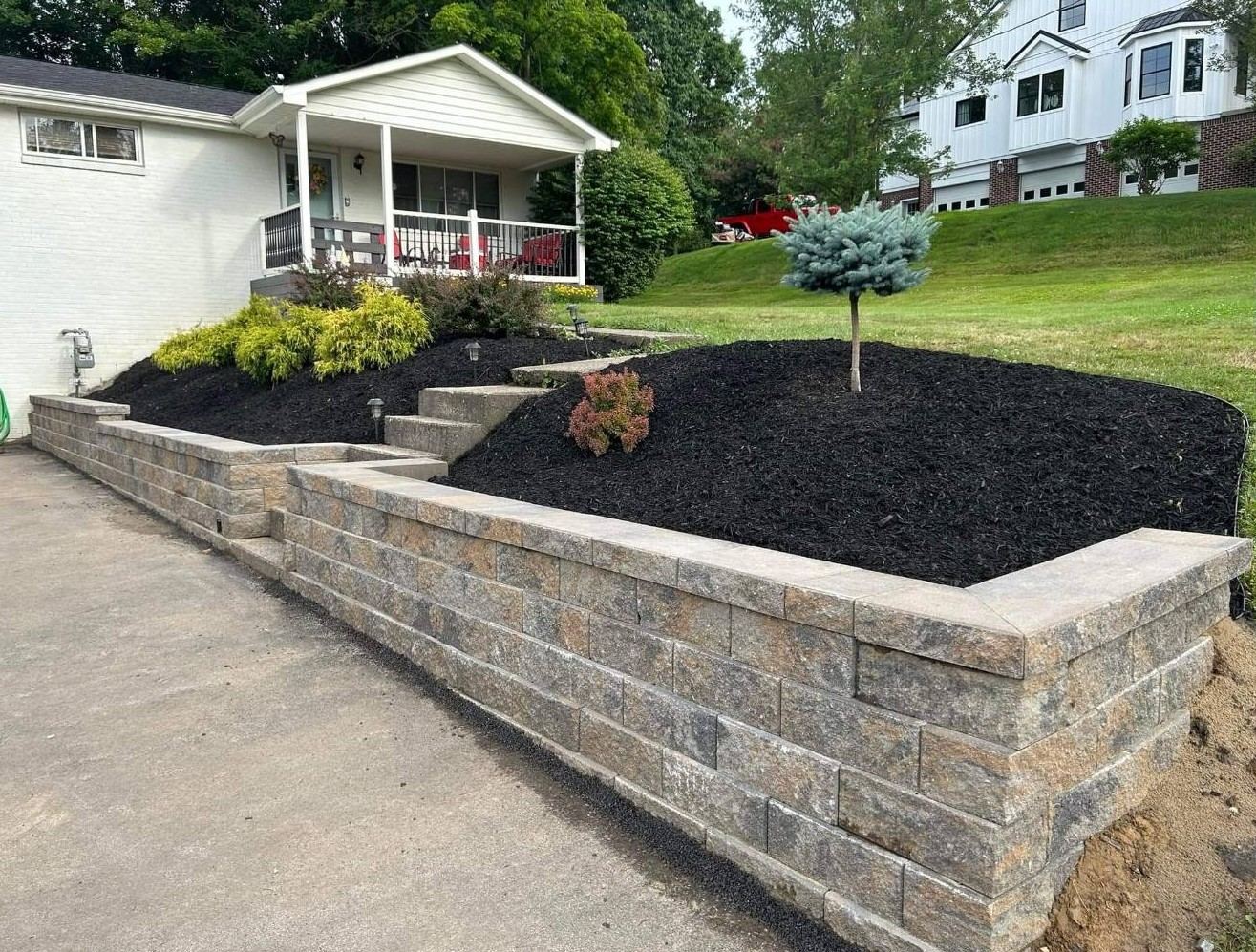 Retaining wall with fresh black mulch and new plantings